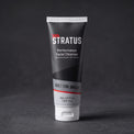 A tube of Stratus Performance Facial Cleanser, part of a post workout skincare routine, standing upright on a dark gray textured surface.