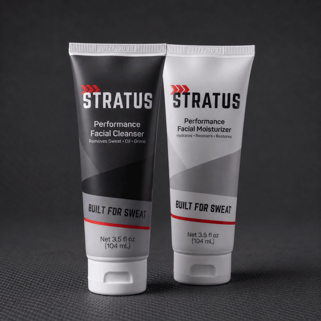 Two squeeze tubes that make up the Stratus Complete System, a post workout skincare routine, are shown on a dark background.