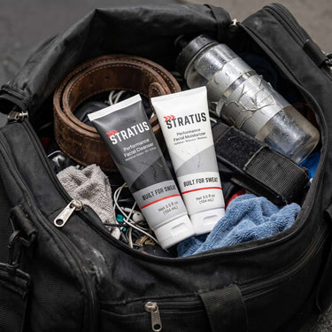 The Stratus Complete System, including a post workout cleanser and a post workout moisturizer, as part of a post exercise skincare routine. The bottles are placed in a black gym bag. 